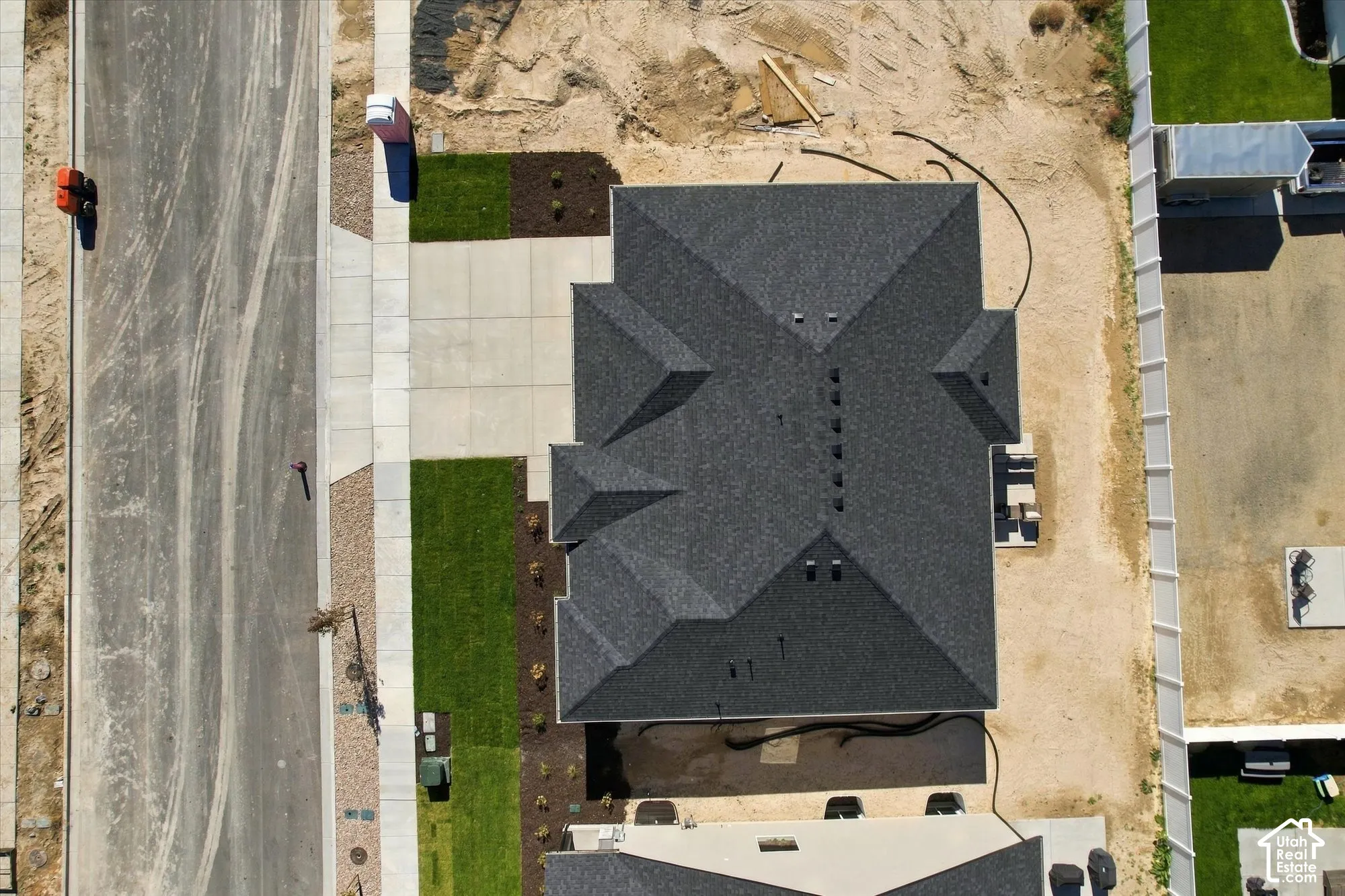Aerial perspective of the residential structure featuring a multi-faceted roofline, asphalt shingles, and an attached concrete driveway