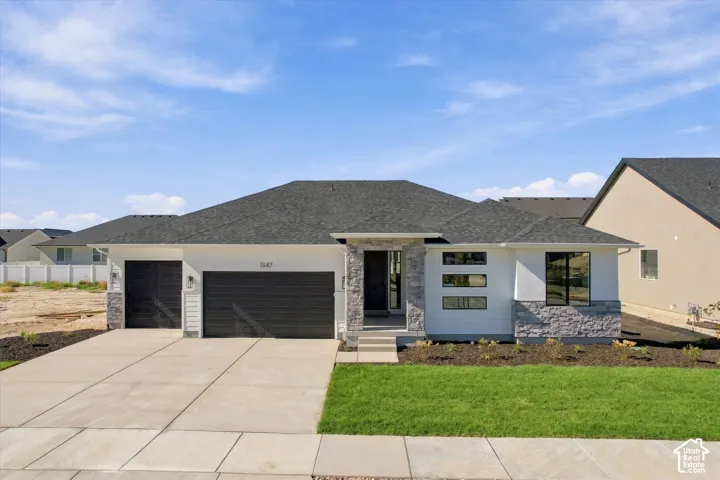 Single-story residence featuring a composite shingle roof, stone veneer accents, horizontal lap siding, a three-car garage, and a concrete driveway