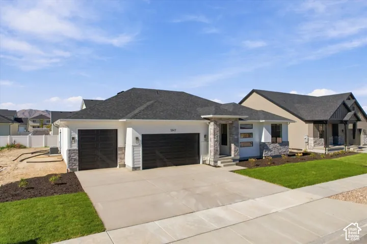 Contemporary exterior featuring a stone veneer facade, horizontal siding, three-car garage, and asphalt shingle roof