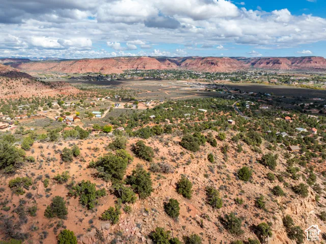 Aerial landscape featuring native desert vegetation, rugged sandstone rock formations, and expansive red rock terrain