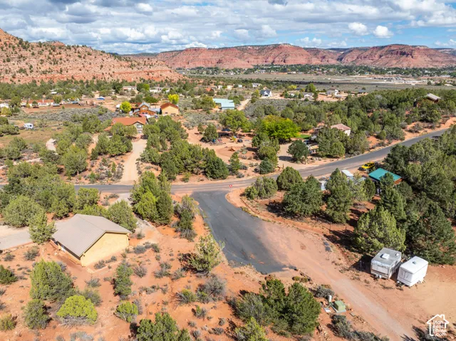Expansive lot featuring native desert vegetation, paved road access, and prominent red rock scenery