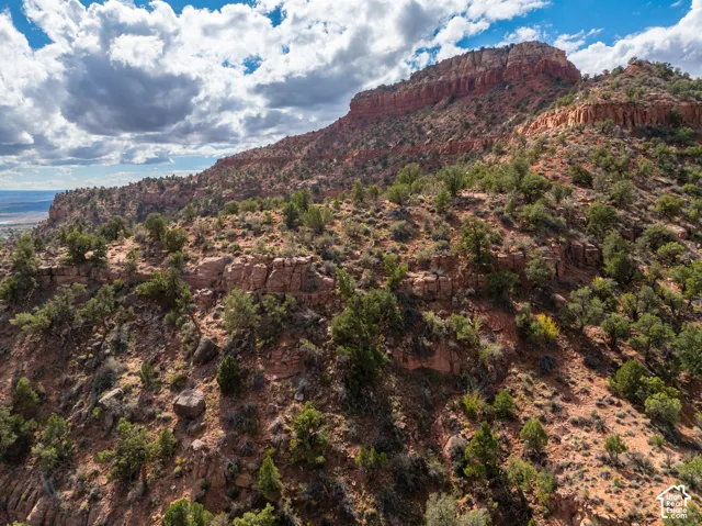 Expansive desert terrain featuring red rock formations, rugged topography, and native shrubbery