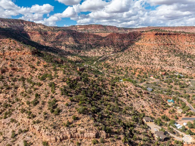 Aerial perspective featuring rugged desert topography, expansive red rock canyon formations and native vegetation