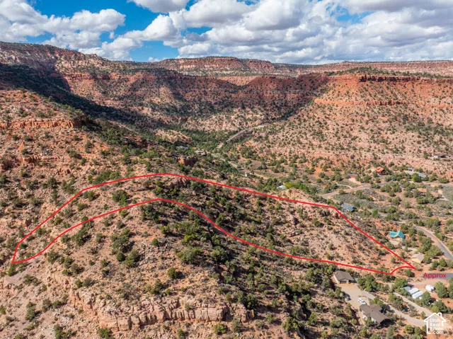 Expansive hillside parcel featuring natural rock formations, native vegetation, and a red rock backdrop