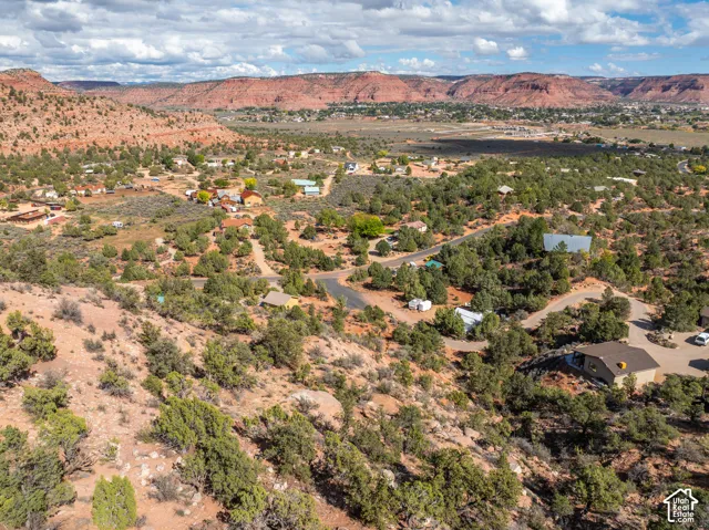 Aerial perspective of high-desert terrain characterized by sandstone rock formations, native vegetation, and expansive natural landscape
