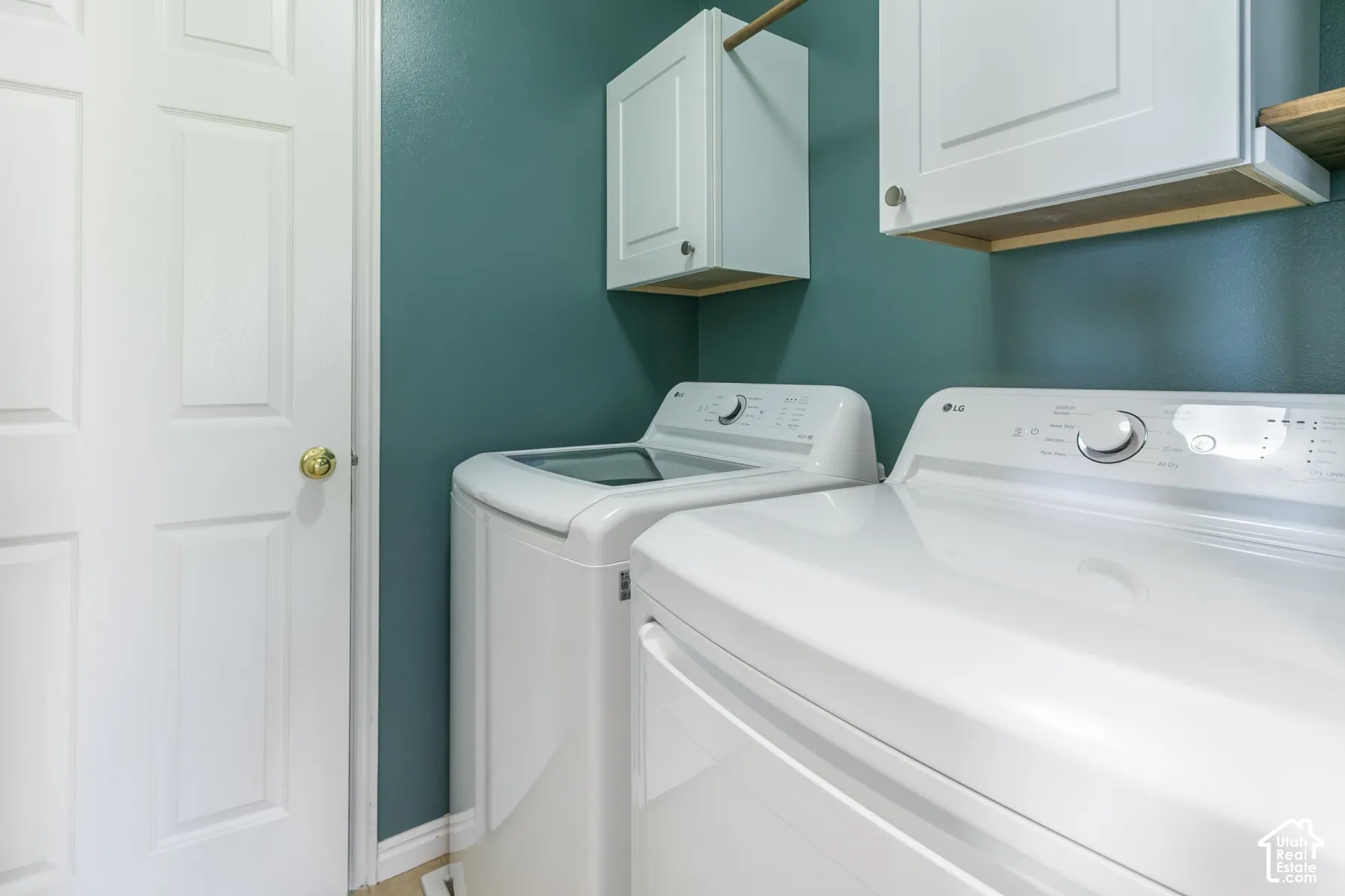 White shaker-style cabinetry with integrated hanging rod and solid surface shelving, complemented by a solid core six-panel door