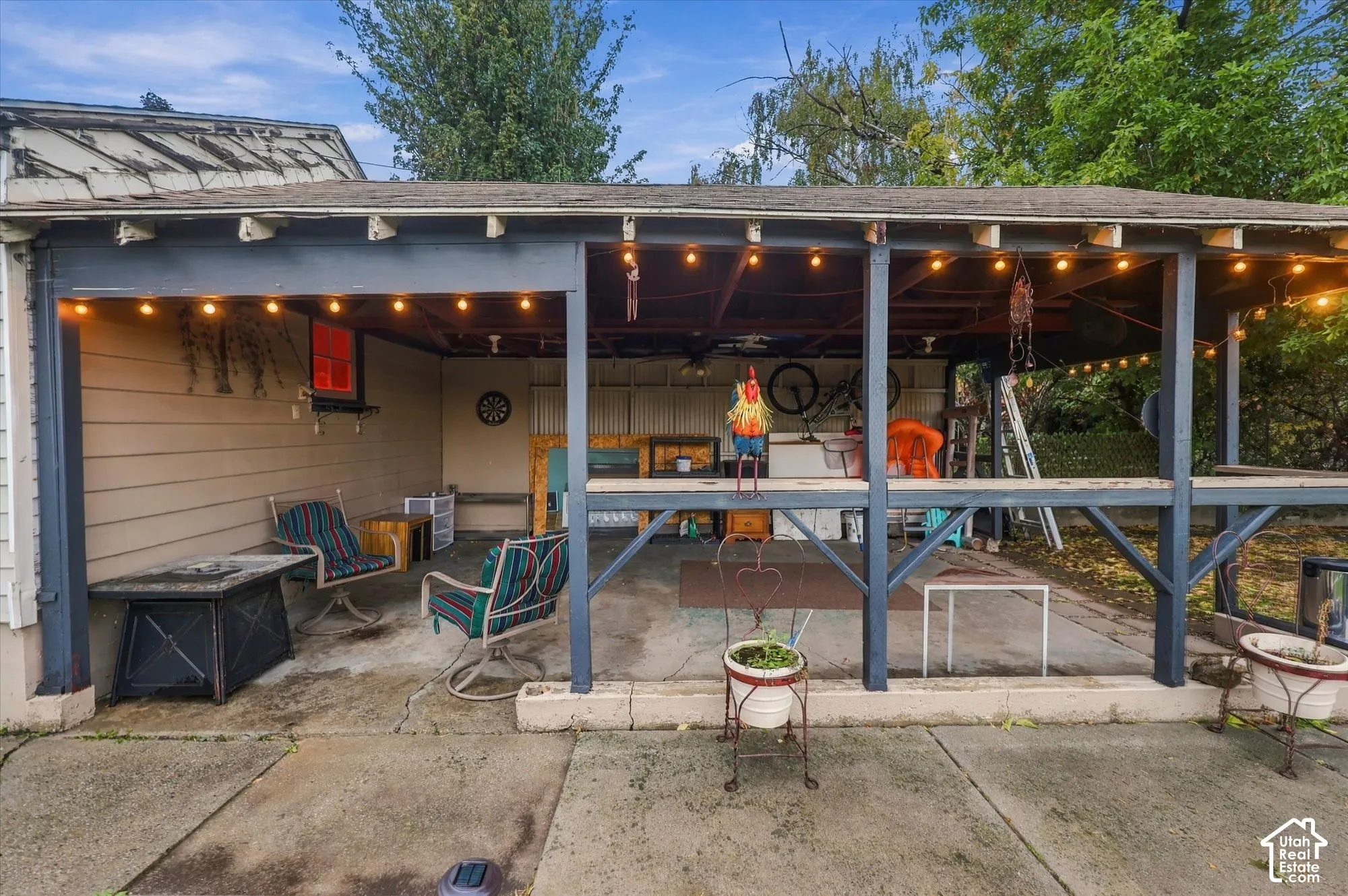 Covered concrete patio featuring timber framing, exposed beam ceiling, and built-in perimeter railing