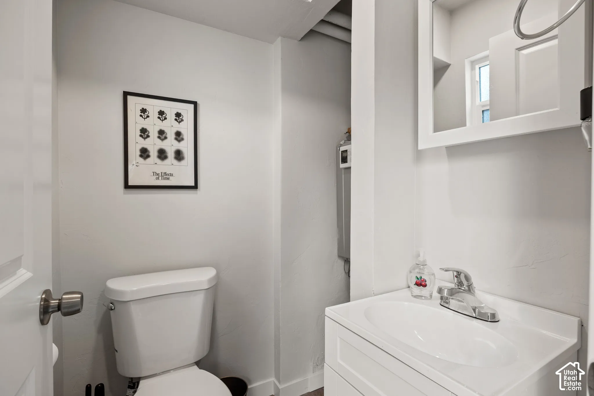 White vanity with an integrated oval sink, chrome single-handle faucet, and wall-mounted medicine cabinet