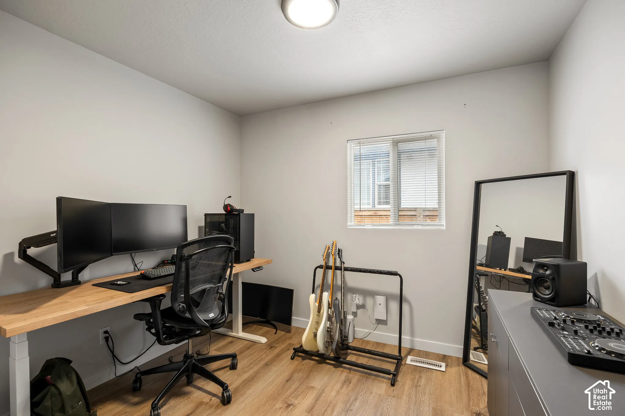Neutral wall paint, wood-finish flooring, and a flush-mount ceiling light fixture
