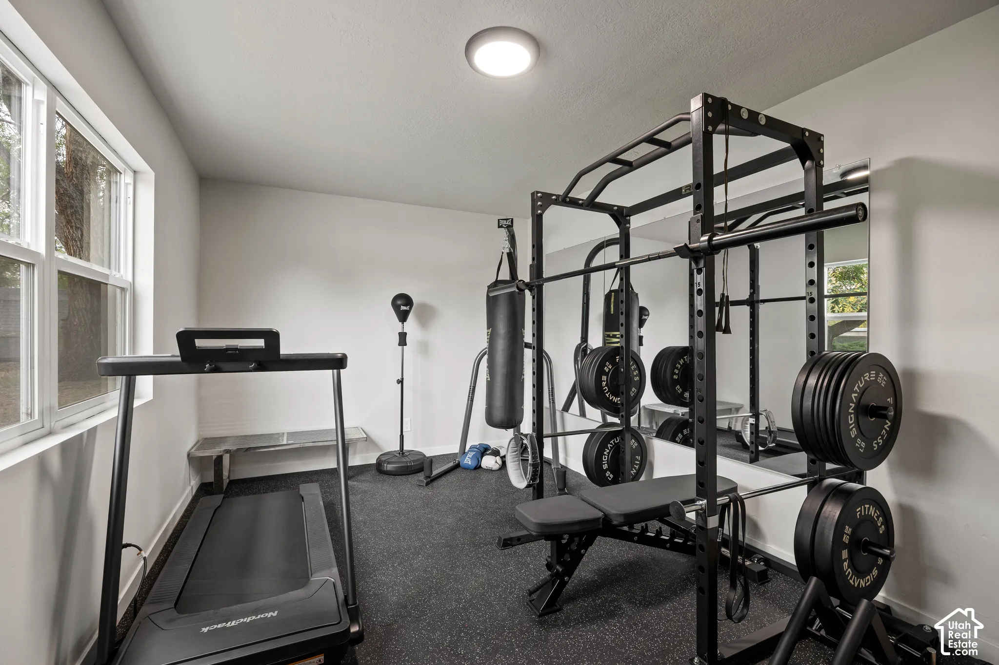 Room featuring high-contrast wall-to-wall mirrors, recessed lighting, and a large window
