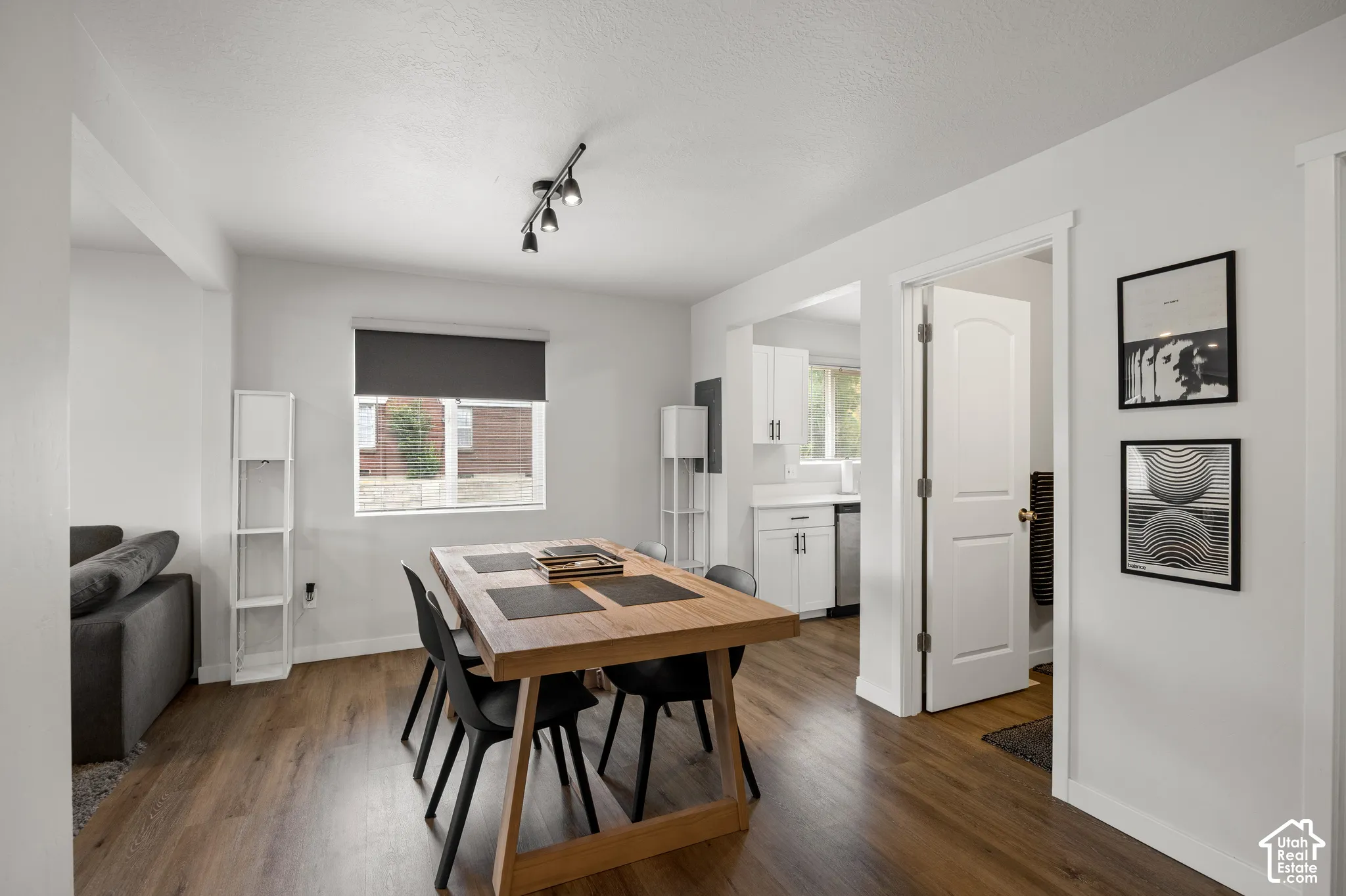 Open-concept space featuring wood-finish flooring, recessed multi-directional track lighting, and a neutral color palette