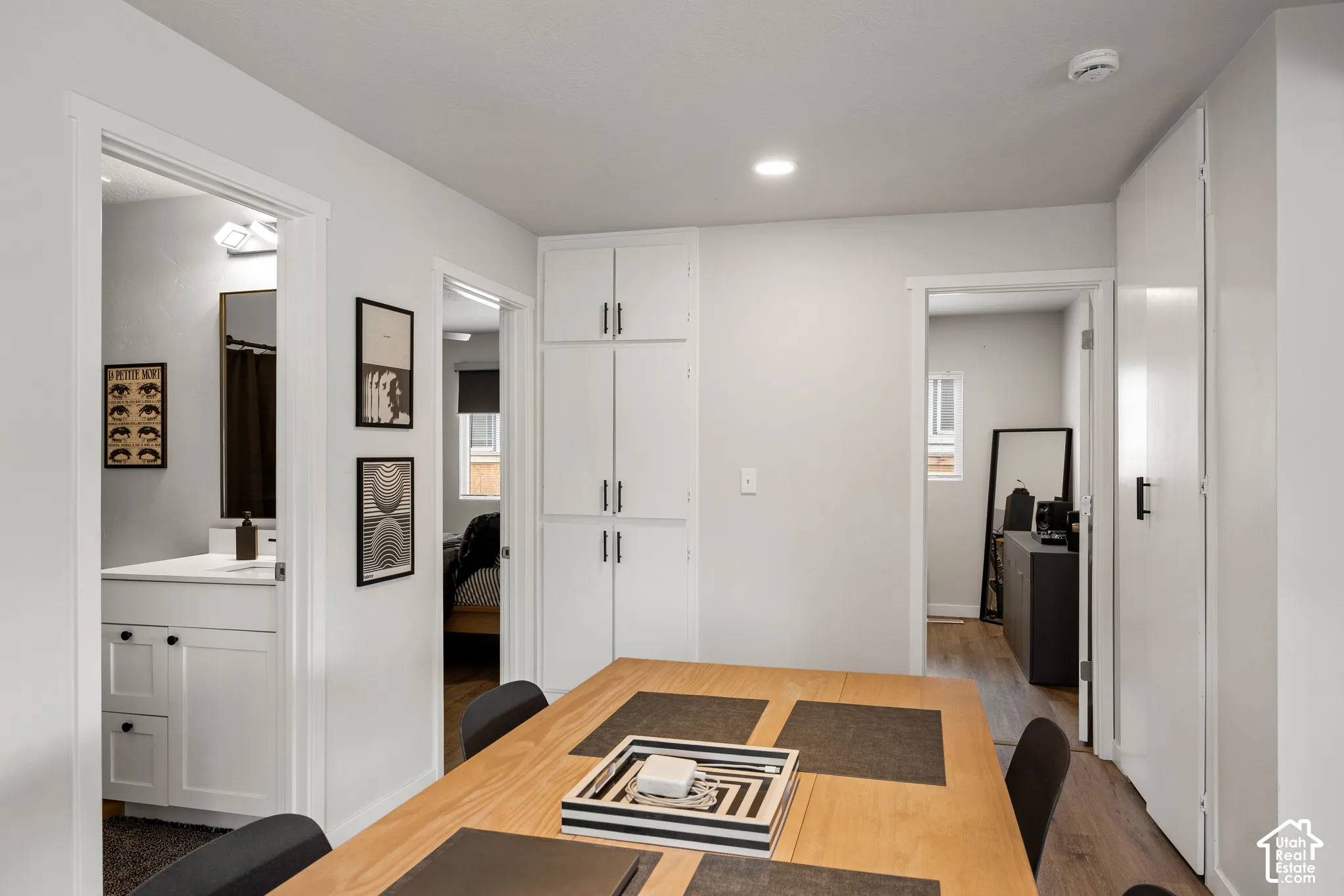 Built-in floor-to-ceiling storage cabinetry with matte black hardware, recessed lighting, and wood-finish flooring