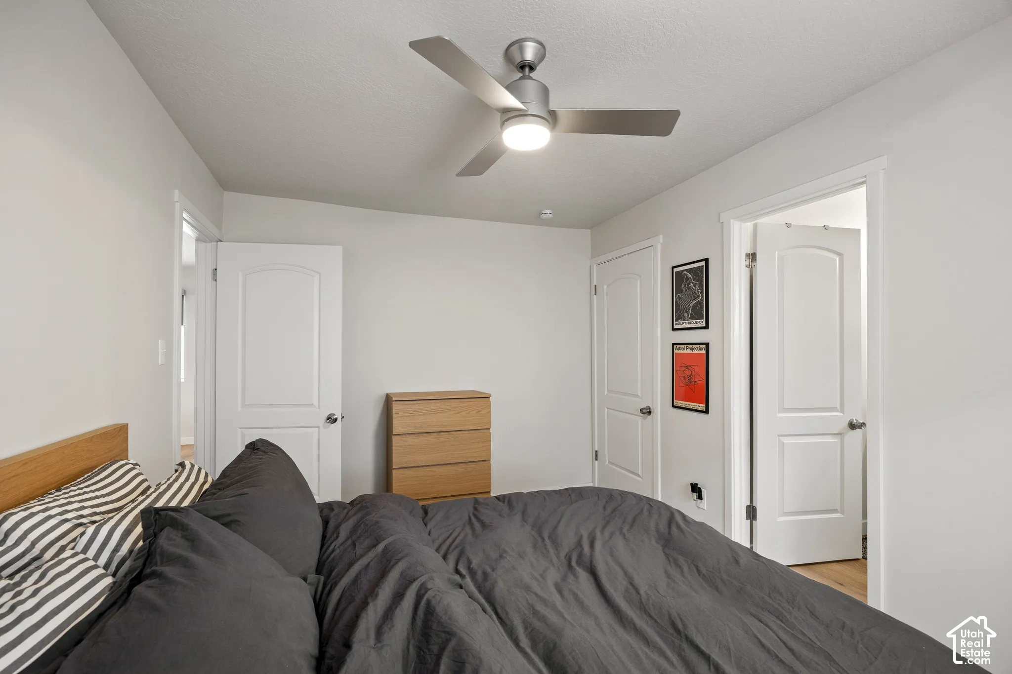 Room featuring a three-blade brushed metal ceiling fan with integrated lighting, two-panel interior doors with brushed nickel hardware, and neutral wall paint