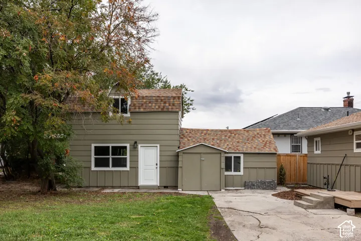 Two-story exterior featuring lap siding, an attached garage with double doors, an asphalt shingle roof, a concrete driveway, and wooden deck steps
