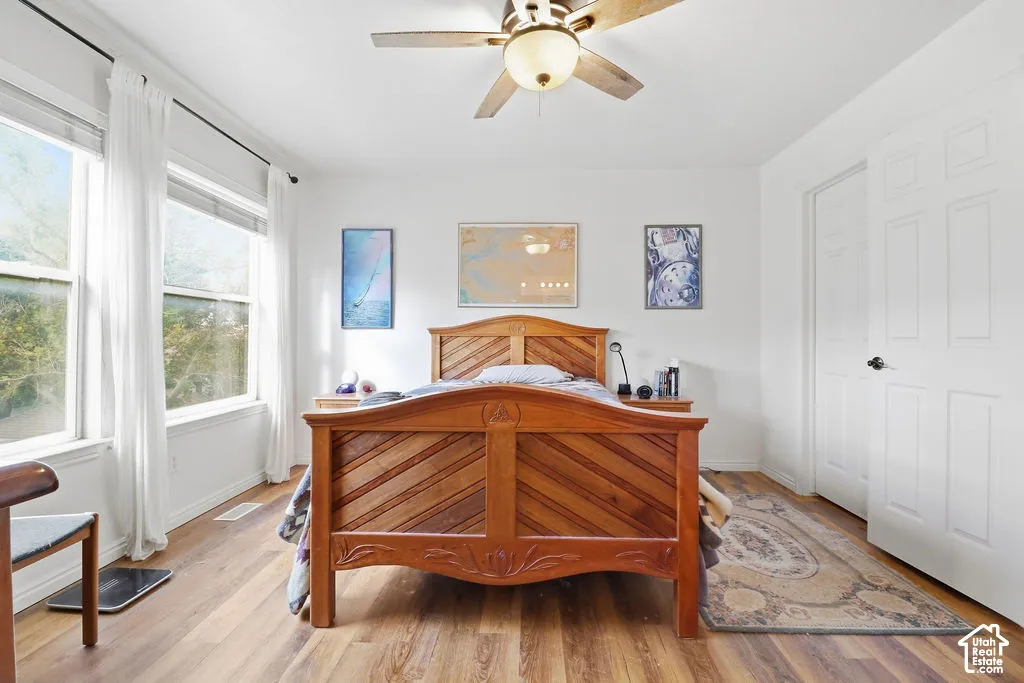 Wood-finish flooring, multi-pane windows, ceiling fan with integrated lighting, and multi-panel interior doors