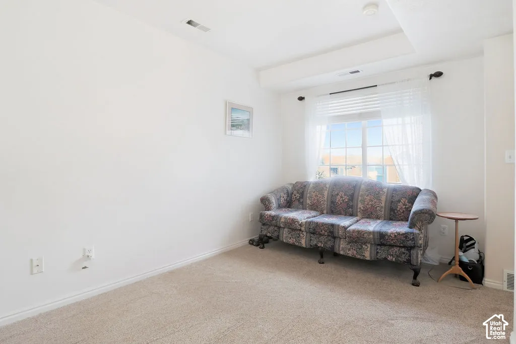 Neutral interior space featuring wall-to-wall carpeting and a window with a muntin grid design