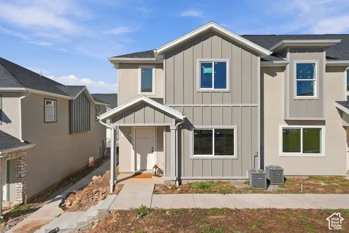 Exterior featuring vertical board-and-batten siding, a covered entryway, asphalt shingle roofing, and energy-efficient double-pane windows