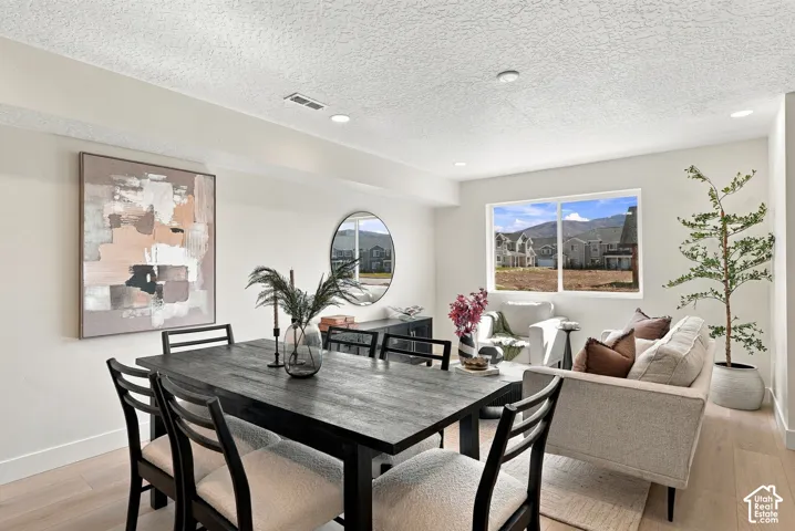 Light-filled room featuring wood-finish flooring, recessed lighting, and a large horizontal window with mountain scenery