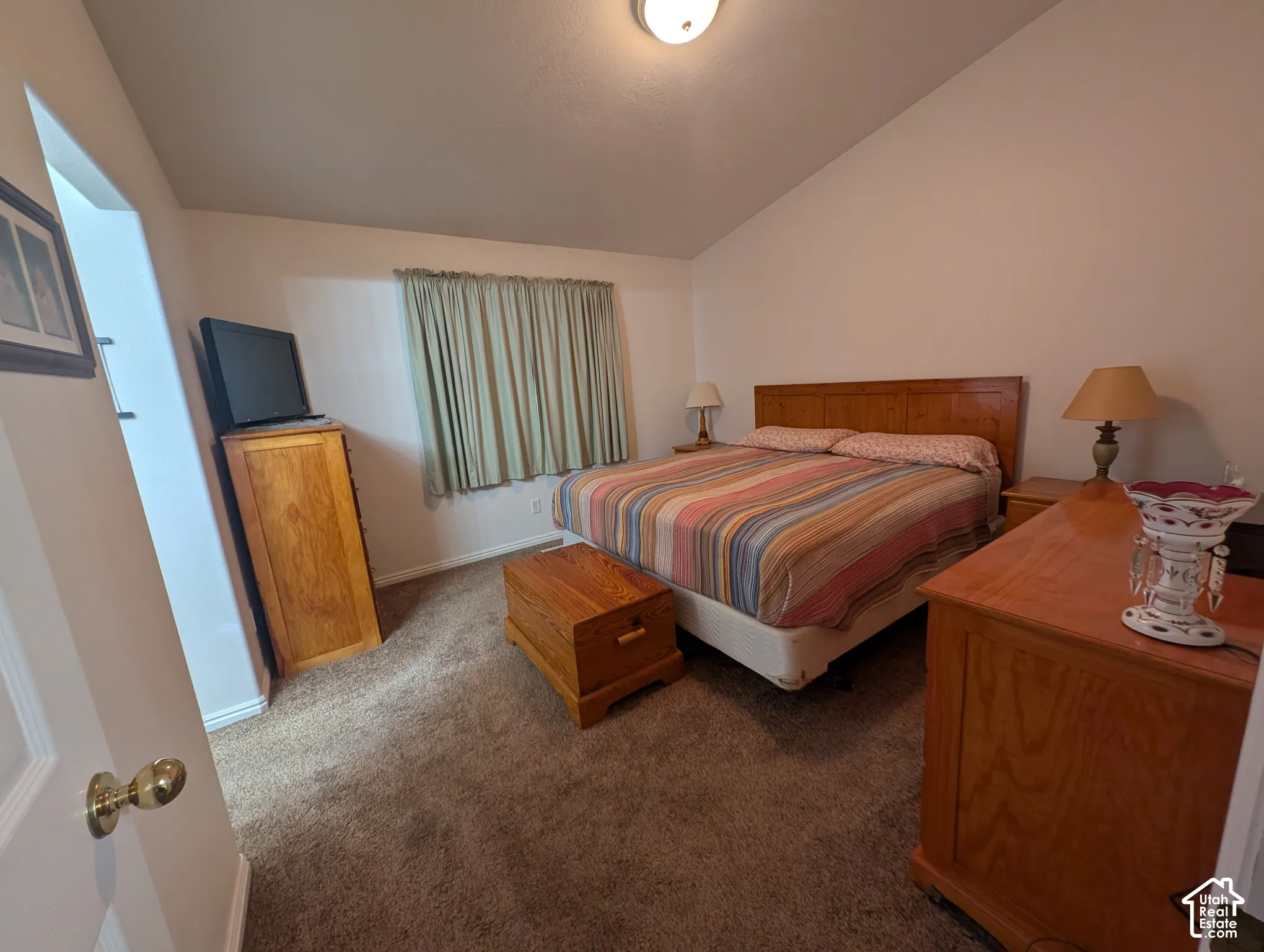 Wall-to-wall carpeting, flush-mount ceiling lighting, and a window with neutral drapery