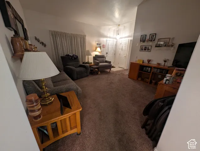 Vaulted ceilings, neutral wall color, and wall-to-wall carpeting