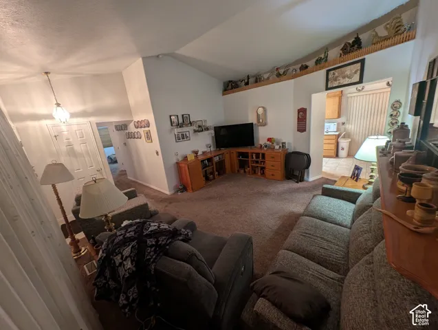 Vaulted ceilings, architectural display ledge, built-in wooden cabinetry, and neutral wall tones