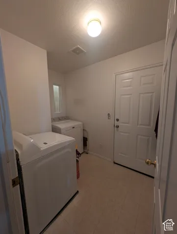 Dedicated utility space featuring resilient vinyl tile flooring, a six-panel exterior door, and a flush-mount circular ceiling fixture
