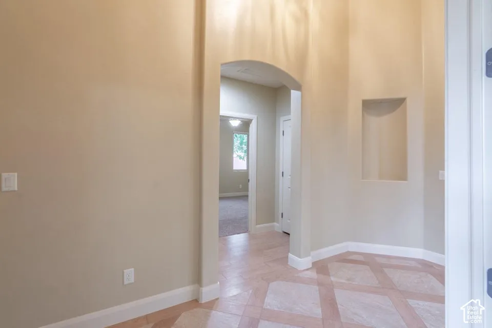 Foyer featuring high ceilings, a recessed wall niche, and tile flooring with a geometric diamond-pattern inlay
