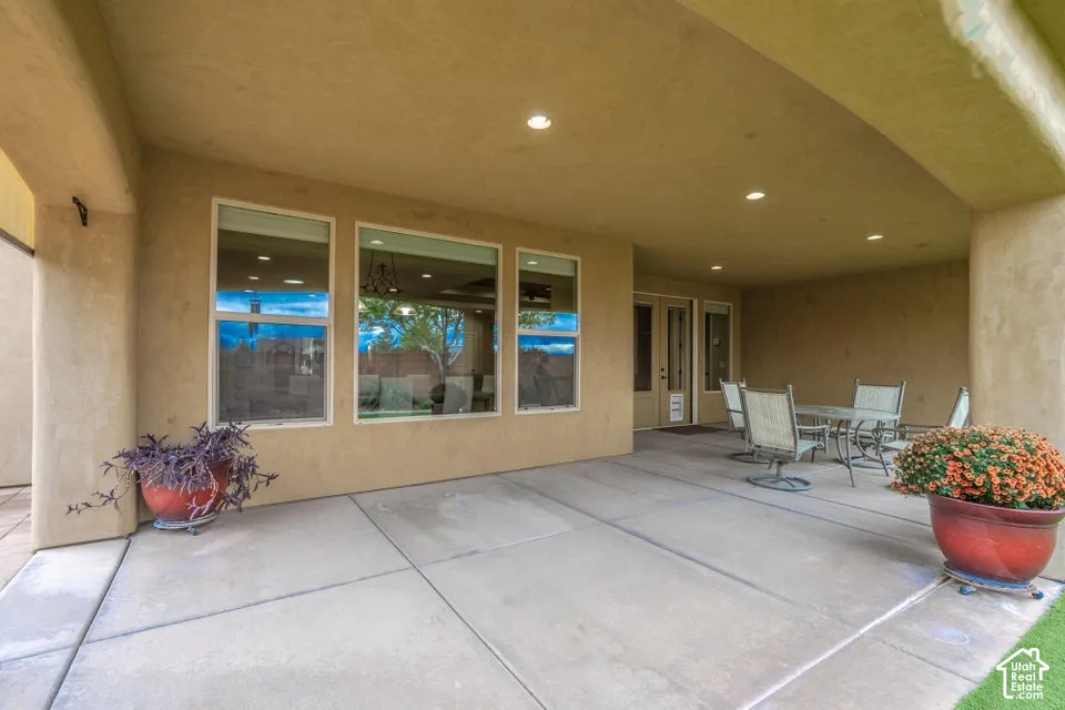 Covered concrete patio featuring recessed lighting, smooth stucco exterior finish, and large rectangular windows