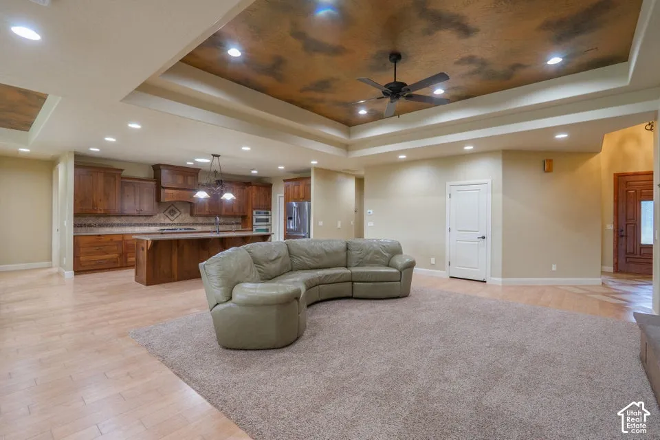 Double tray ceiling featuring decorative faux finish, recessed lighting, and a central ceiling fan