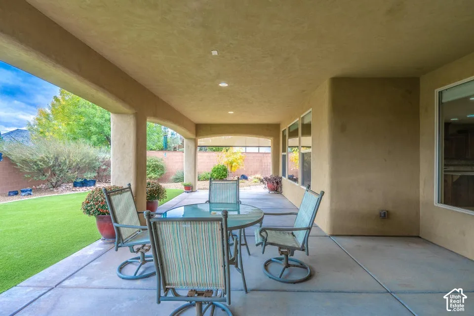 Covered patio featuring a concrete floor, stucco columns, recessed lighting, and a masonry perimeter wall