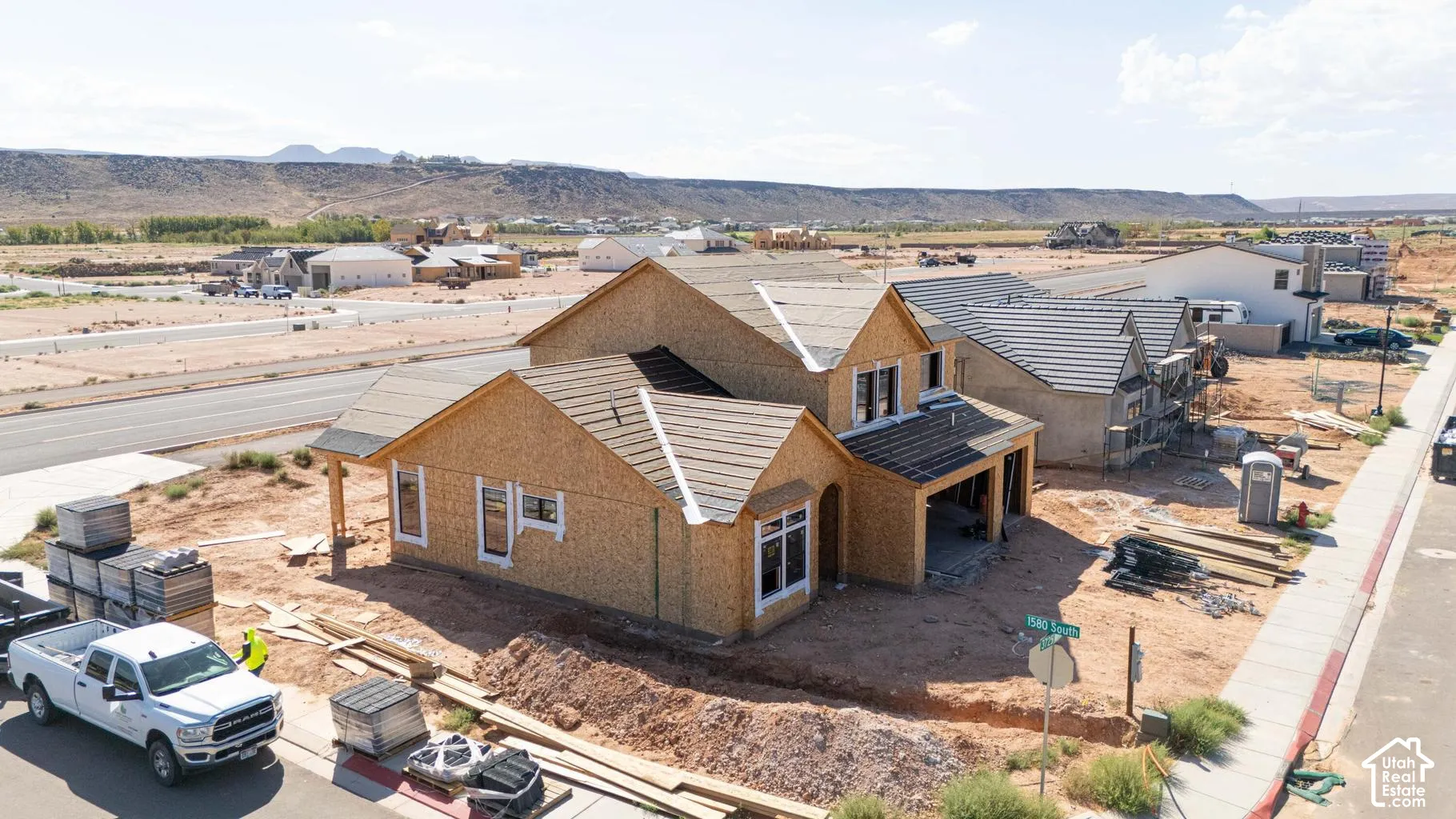 New construction home featuring a wood-frame structure, multi-pitch roofline, and integrated garage, set against a mountain backdrop