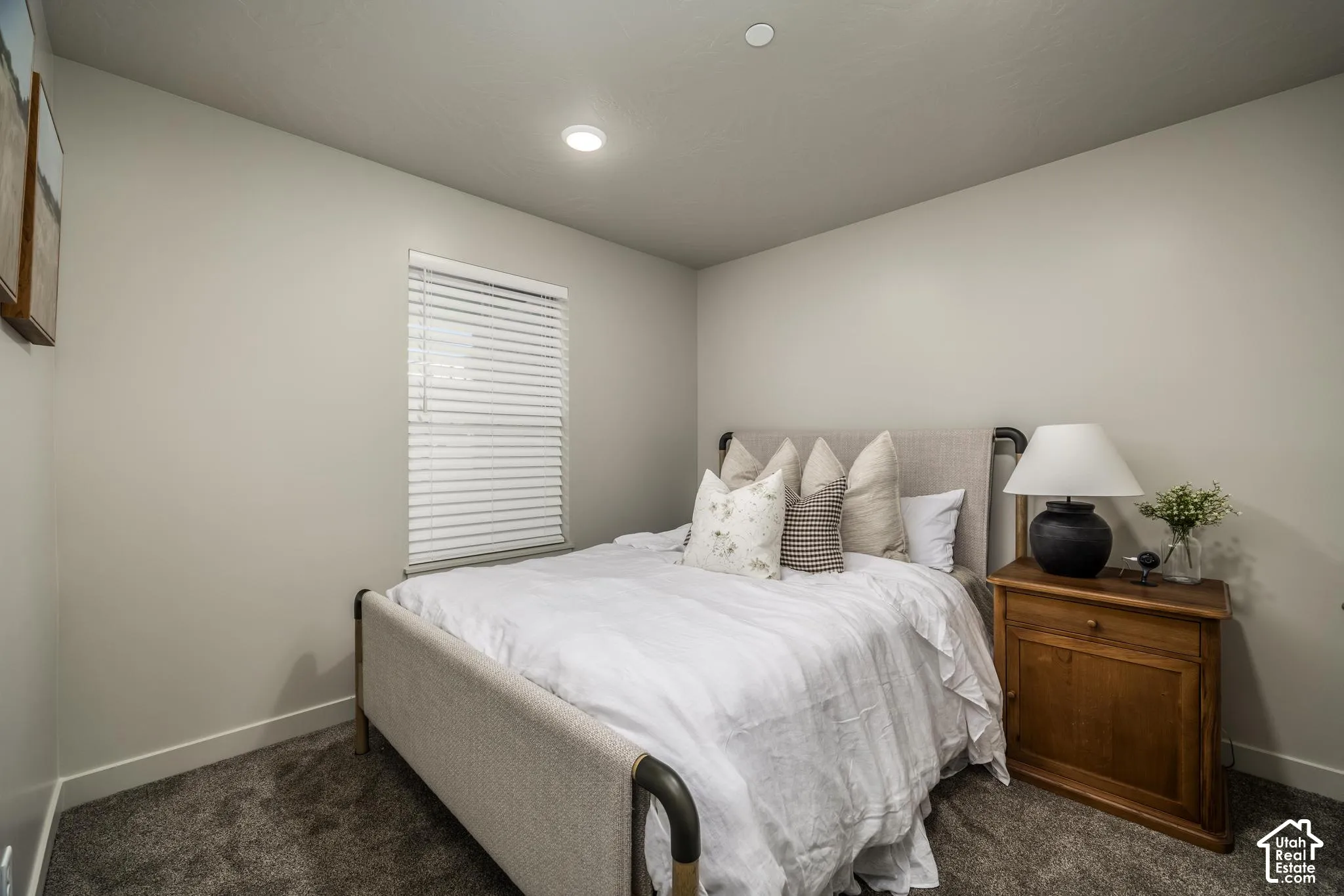 Neutral-toned interior featuring wall-to-wall carpeting, recessed ceiling lighting, and a single-pane window with integrated blinds