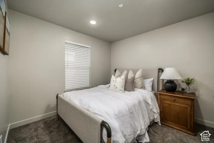 Neutral-toned interior featuring wall-to-wall carpeting, recessed ceiling lighting, and a single-pane window with integrated blinds