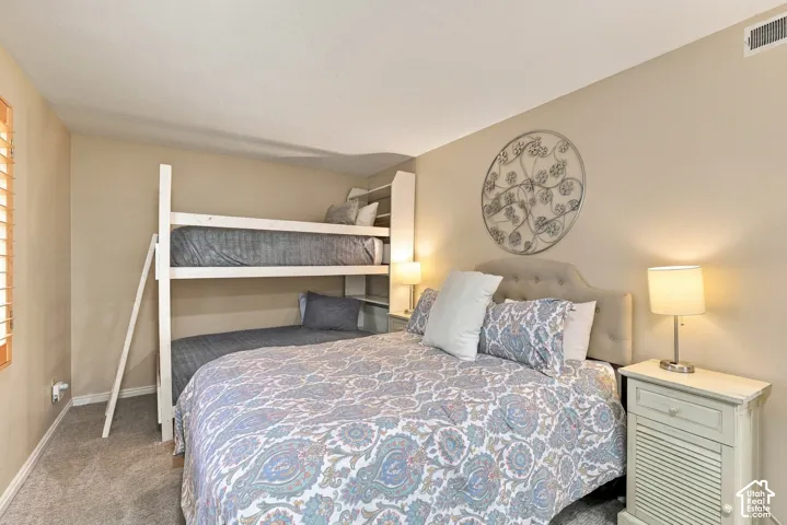 Neutral-toned interior space featuring wall-to-wall carpeting, wood shutter window treatments, and textured wall surfaces
