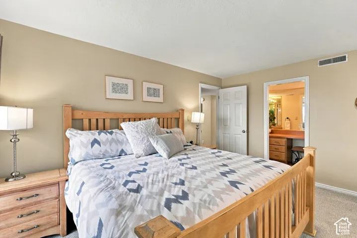 Neutral wall tones, wall-to-wall carpeting, and a six-panel interior door