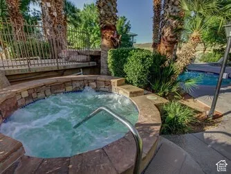 Circular spa with stone surround, integrated steps, and adjacent pool
