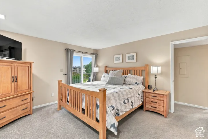 Neutral-toned room featuring wall-to-wall carpeting and sliding glass doors with access to an exterior balcony