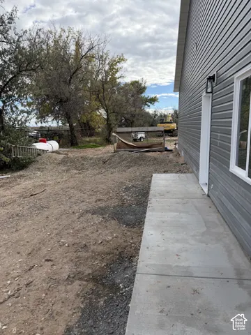 Horizontal lap siding exterior with a concrete pathway and wall-mounted exterior lighting fixture