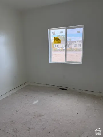 Neutral interior space featuring white walls and a dual-pane sliding window