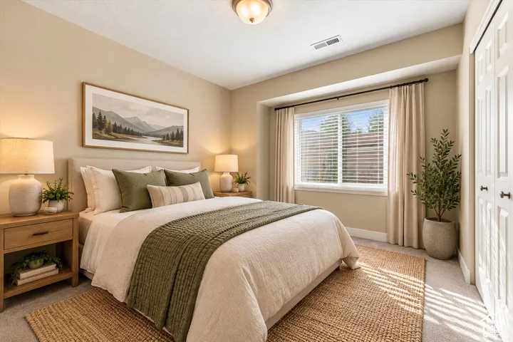 Neutral-toned interior space featuring a recessed window with an integrated blind, wall-to-wall carpeting, and double-panel closet doors with dark hardware