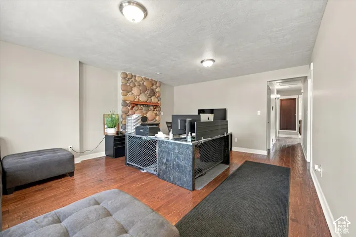 Interior space featuring wood-finish flooring, a floor-to-ceiling river rock fireplace, and flush-mount ceiling lighting