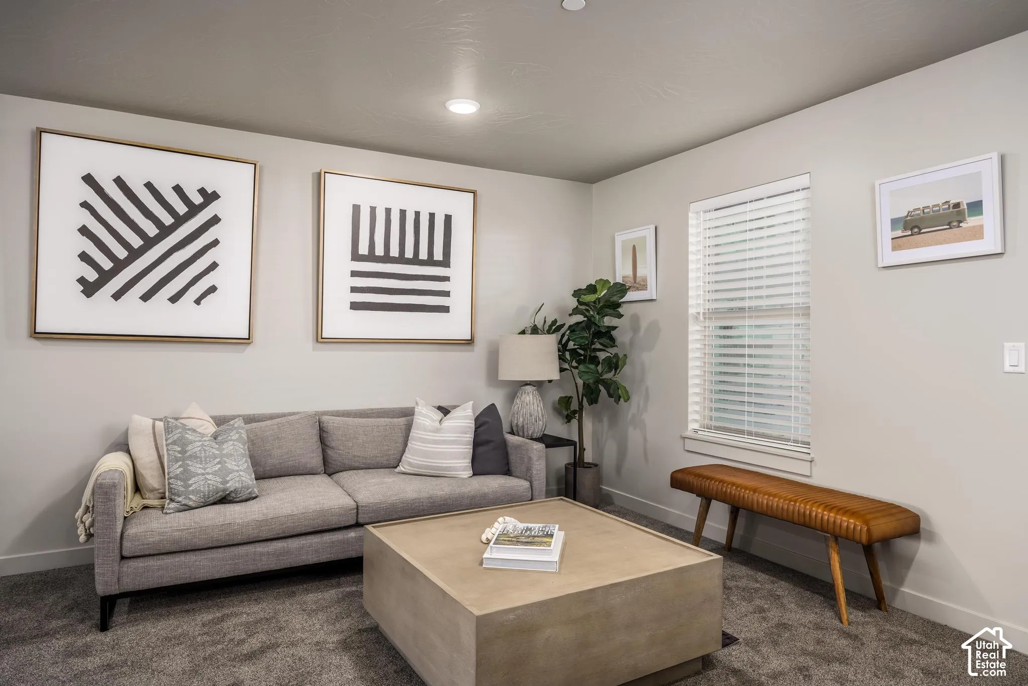 Neutral-toned interior space featuring wall-to-wall carpeting and a window equipped with horizontal blinds