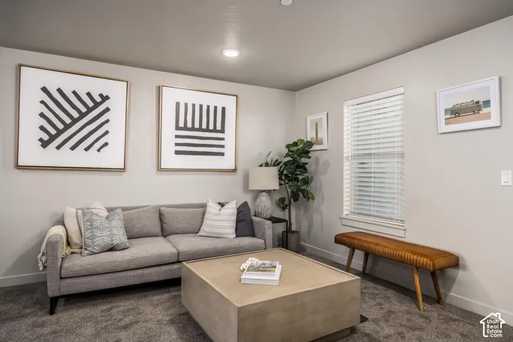 Neutral-toned interior space featuring wall-to-wall carpeting and a window equipped with horizontal blinds
