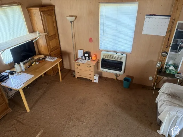 Wood-paneled interior walls, wall-mounted heating unit, and dual windows with horizontal blinds