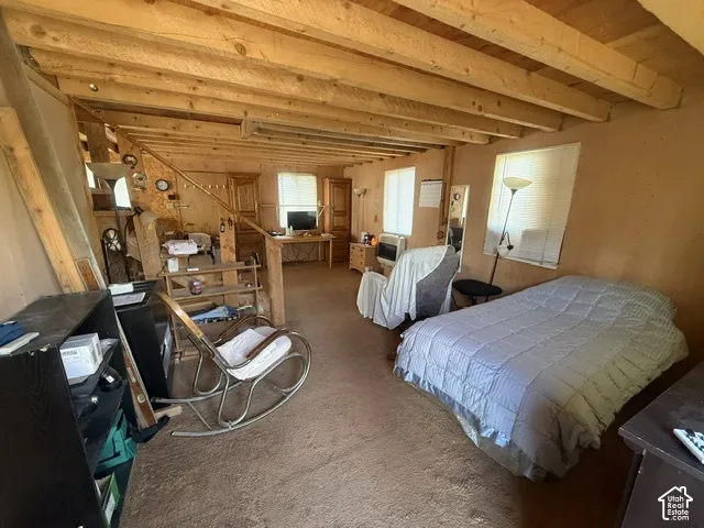 Interior space featuring exposed wood ceiling beams and multiple windows with integrated blinds