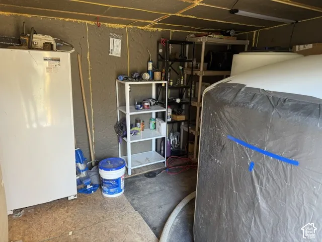 Utility area featuring spray-foam insulation, a reinforced concrete floor, and linear LED lighting