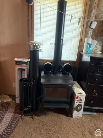 Black metal freestanding stove featuring a glass-panel door and dual-vented flue system