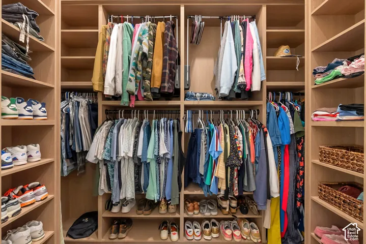 Custom walk-in closet featuring floor-to-ceiling built-in cabinetry, adjustable shelving, integrated hanging rods, and specialized shoe storage cubbies