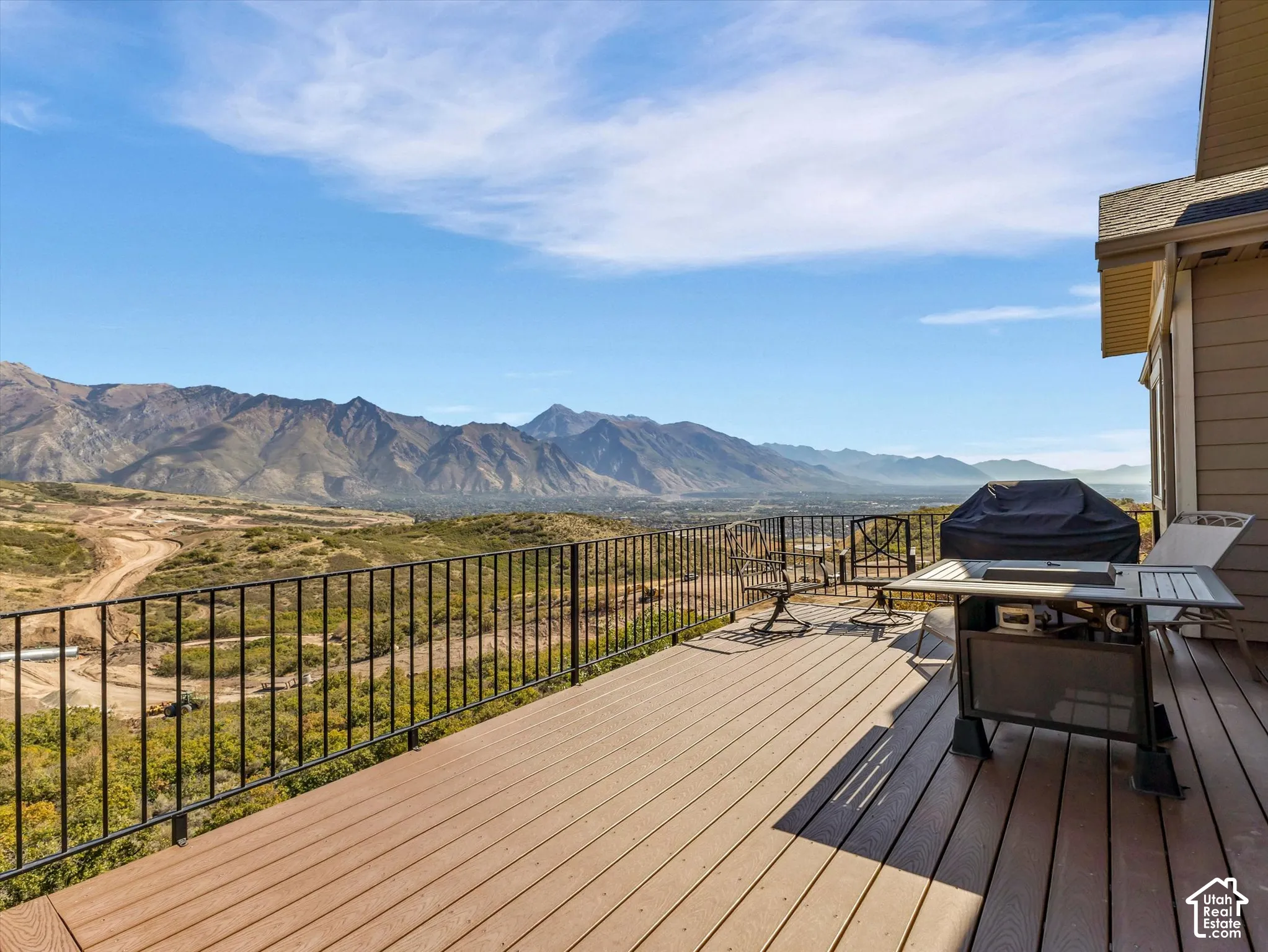Raised deck featuring composite decking, black metal railing, and expansive mountain scenery