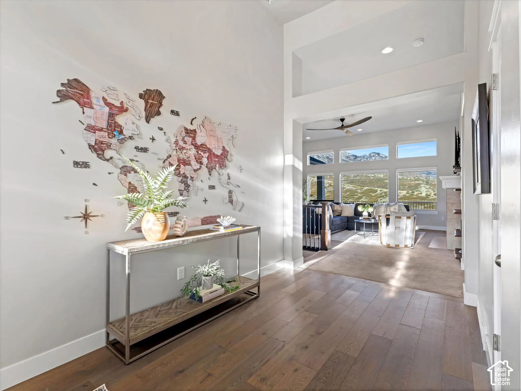 Vaulted ceilings, wood-finish flooring, recessed lighting, and expansive windows showcasing a mountain backdrop